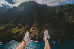 two feet appearing over the edge of a cliff